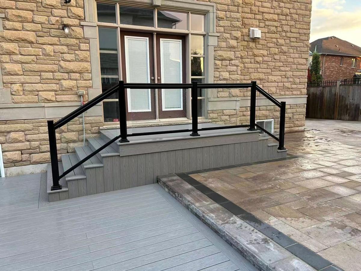 Rebuilt front entrance with stone steps and a black glass railing