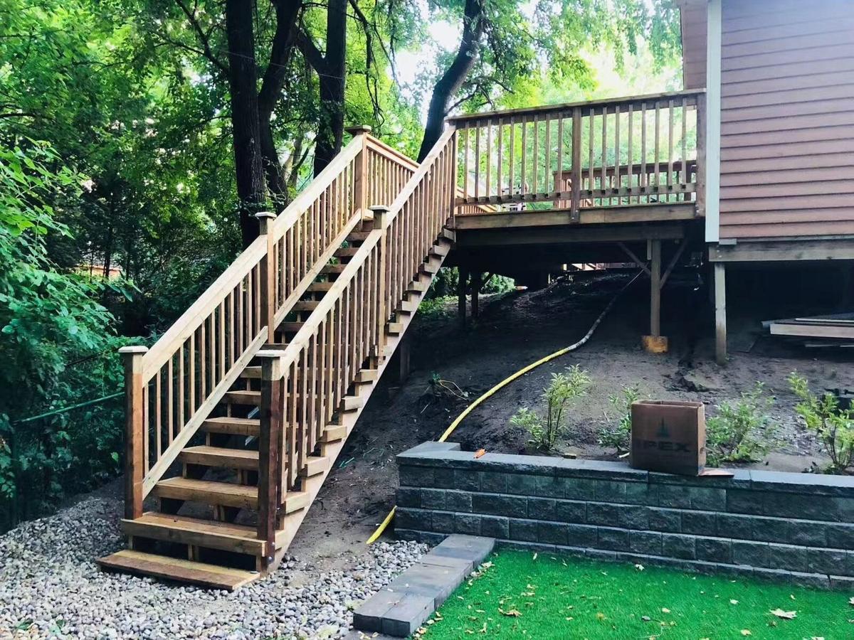 Cedar deck and staircase with railings built over a retaining wall